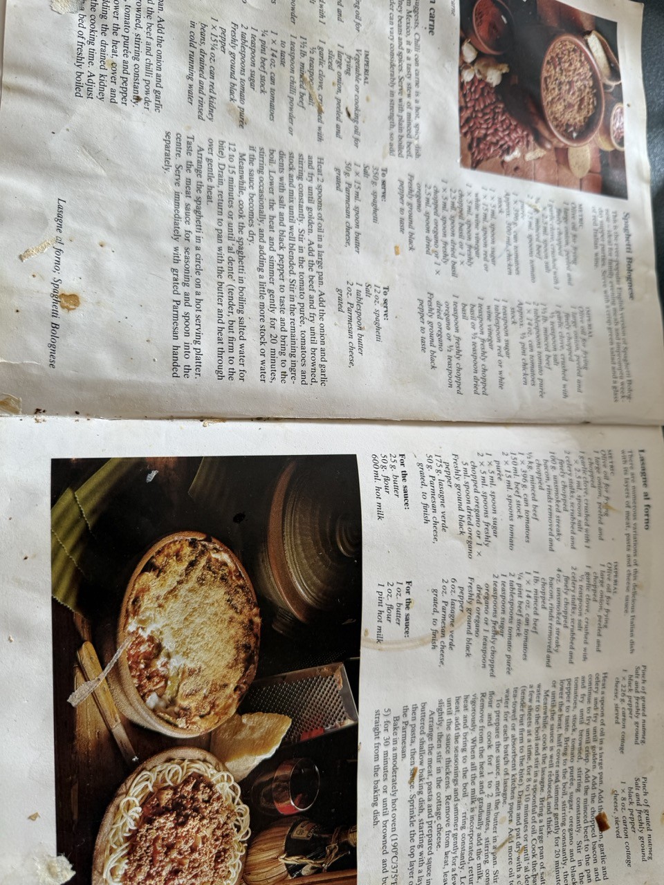 Photograph of an open recipe book. The pages are slightly stained and crinkled, with dried blobs of food and cup rings on them. 