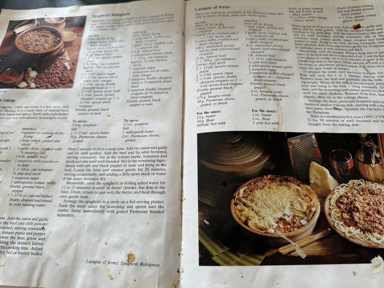 Photograph of an open recipe book. The pages are slightly stained and crinkled, with dried blobs of food and cup rings on them. 