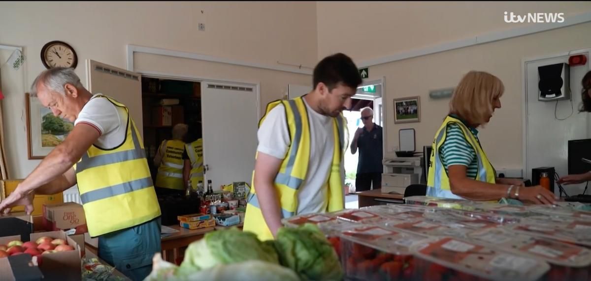 Photograph of myself and two other food bank volunteers sorting out food donations for people to collect.